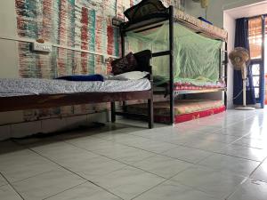 a bedroom with a bunk bed and a tiled floor at B Hostel in Fort Kochi