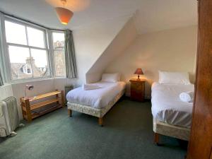 um quarto com 2 camas e uma janela em Abbotsford Place - Sleeps 6 - Parking em St. Andrews