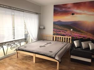 een slaapkamer met een bed en een schilderij aan de muur bij Tatrzańskie Zacisze in Suche