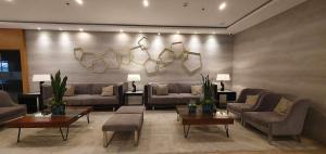 a living room with couches and tables and lamps at C Place - Capsule A in Manila +1 photo