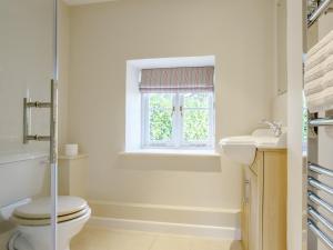 a bathroom with a toilet and a sink and a window at 5 Bed in Sherborne 79062 in Wincanton