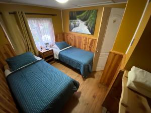 ein kleines Zimmer mit 2 Betten und einem Fenster in der Unterkunft Hostería Futaleufu in Futaleufú