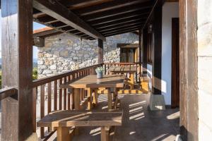 un patio con tavoli e panche in legno su un edificio di BARRUTI LANDARBIDE - Para desconectar en plena naturaleza ad Aia