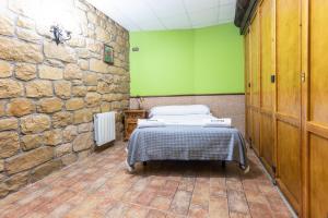 a bedroom with a bed and a stone wall at BARRUTI LANDARBIDE - Para desconectar en plena naturaleza in Aia