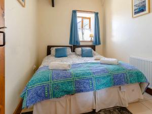 a bedroom with a large bed with blue curtains at 1 bed property in Brynteg 81354 in Llanwenog