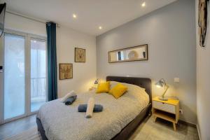 カンヌにあるLe Chris - Centre - Wifi - Verrière Côte d'Azurのベッドルーム1室(黄色い枕のベッド1台、窓付)