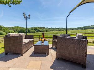 a patio with two wicker chairs and a table at 1 Bed in Hereford 81293 in Aconbury