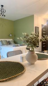a vase with flowers on a table in a bedroom at Roztocka studio, free parking, 1 tram to the city & PGE National Stadion, by Cosmo Spirit in Warsaw