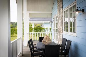 a patio with a table and chairs on a porch at De Gouden Spar in Noordwijk