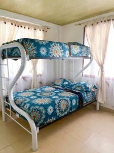 een slaapkamer met een stapelbed met blauwe en witte lakens bij El piedron in Bogota