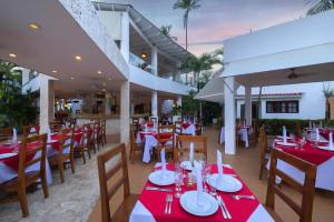 un restaurante con mesas y sillas rojas y blancas en Hotel whala!bávaro - All Inclusive, en Punta Cana