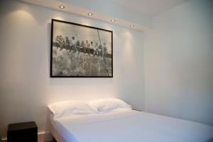a bedroom with a white bed with a picture on the wall at TASTY LUXURY 3 BEDROOM FULL VIEW SEINE-NOTRE DAME in Paris
