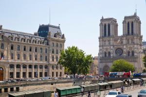 a large building with cars parked in front of it at TASTY LUXURY 3 BEDROOM FULL VIEW SEINE-NOTRE DAME in Paris