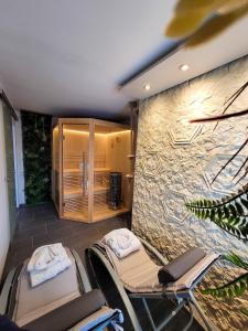 a spa room with chairs and a stone wall at Blissberg Winterberg in Winterberg