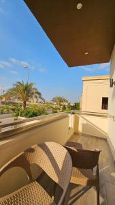 una silla de mimbre sentada en un balcón con vistas al océano en My Villa en Sheikh Zayed