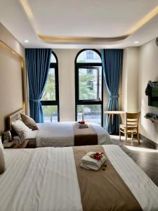 a hotel room with two beds and two windows at Teddy 96 Homestay & Cafe-3 stars-Grand World Phu Quoc in Phu Quoc