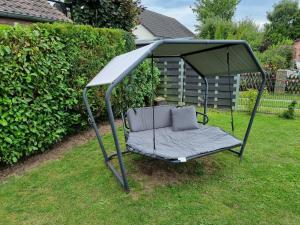 a canopy bed in the grass in a yard at Ferienhaus Bojenweg in Rostock