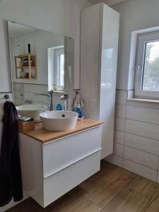 a bathroom with two sinks and a mirror at Ferienhaus Bojenweg in Rostock
