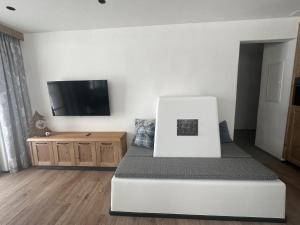 1 dormitorio con 1 cama y TV de pantalla plana en Samnaun, ChaletdMot en Samnaun