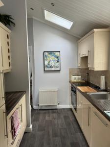 a kitchen with white cabinets and a skylight at V+B Hygge in Windermere