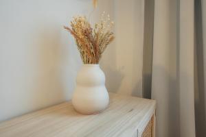 um vaso branco com flores em cima de uma mesa em Brand-new 2-room apartment in a top location em Viena