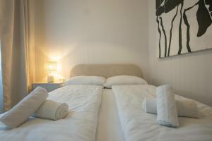 duas camas num quarto com lençóis brancos e toalhas em Brand-new 2-room apartment in a top location em Viena