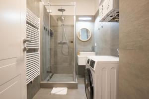 een badkamer met een douche en een wasmachine bij Brand-new 2-room apartment in a top location in Wenen
