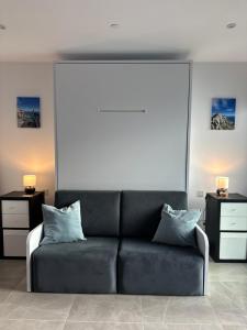 sala de estar con sofá negro y 2 mesas en E1 Apartment High Level Sea View en Gibraltar