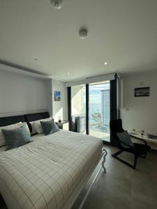 1 dormitorio con 1 cama, 1 silla y 1 ventana en E1 Apartment High Level Sea View en Gibraltar