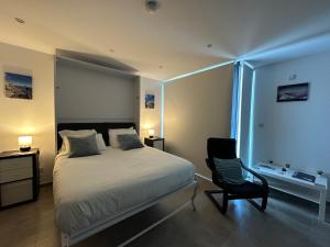 1 dormitorio con 1 cama y 1 silla negra en E1 Apartment High Level Sea View en Gibraltar