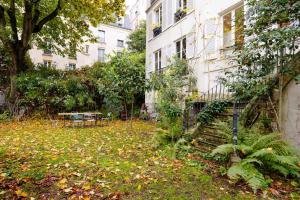 a yard with leaves on the ground next to a building at Veeve - Artist's Imprint in Paris