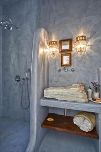 a bathroom with a shower and a bed and a sink at Arvanitis Cave Village in Akrotiri