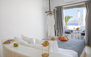 a white living room with a couch and a table at Arvanitis Cave Village in Akrotiri