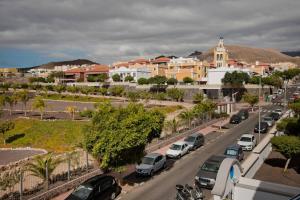 uma rua da cidade com carros estacionados na estrada em Mencey em San Miguel de Abona