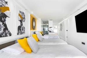 une chambre avec trois lits avec des oreillers jaunes et blancs dans l'établissement Lujo Borinquen 403 Vista al mar, à Playa de Fañabé 28 autres photos