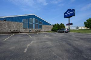 une voiture garée dans un parking en face d'un bâtiment dans l'établissement AmericInn by Wyndham Monroe, à Monroe