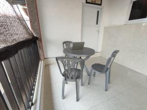 einen Tisch und Stühle sowie einen Laptop auf dem Balkon in der Unterkunft SPOT ON 93367 Wisma Sidosari Syariah in Lampung
