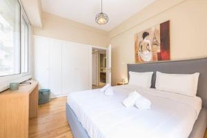 a bedroom with a large white bed and a window at Syntagma H&B Apartment in Athens