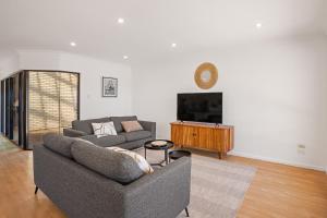 a living room with a couch and a tv at Waterfront Villa Provence in Port Lincoln