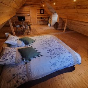 1 dormitorio con 2 camas y una mesa en una cabaña en La Maison En Bois 