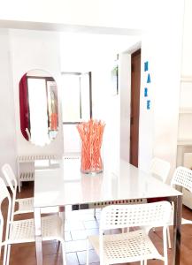 een witte eetkamer met een witte tafel en witte stoelen bij Trilocale 30 Residence La Giungla in Falerna Marina