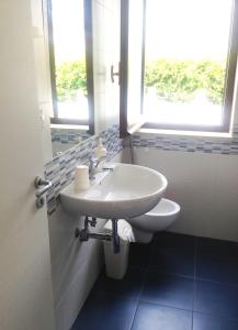 een witte wastafel in een badkamer met een raam bij Trilocale 30 Residence La Giungla in Falerna Marina