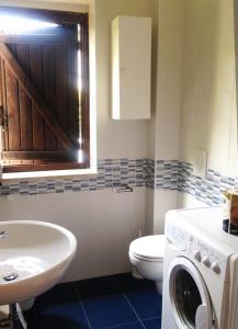 een badkamer met een toilet, een wastafel en een wasmachine bij Trilocale 30 Residence La Giungla in Falerna Marina