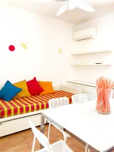 een woonkamer met een bank en kleurrijke kussens bij Trilocale 30 Residence La Giungla in Falerna Marina