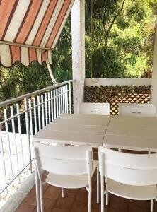 een witte tafel en stoelen op een balkon bij Trilocale 30 Residence La Giungla in Falerna Marina