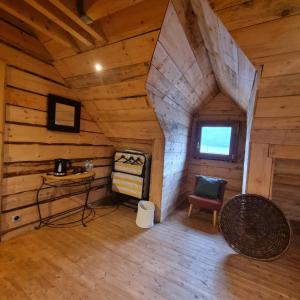 an attic room of a log cabin with a table and a chair at La Maison En Bois 