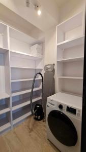 a washing machine in a room with white shelves at Apartament Zygmuntowski in Gliwice