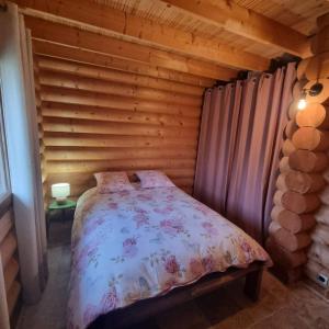 a bedroom with a bed in a log cabin at La Maison En Bois 