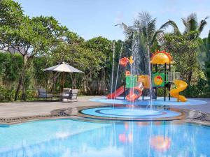 uma piscina com um parque aquático com um escorrega aquático em Grand Mercure Bali Seminyak em Seminyak