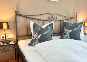 a bed with black and white pillows in a bedroom at Hillside One - Ski-In Ski-Out Apartments am Arlberg in Warth am Arlberg